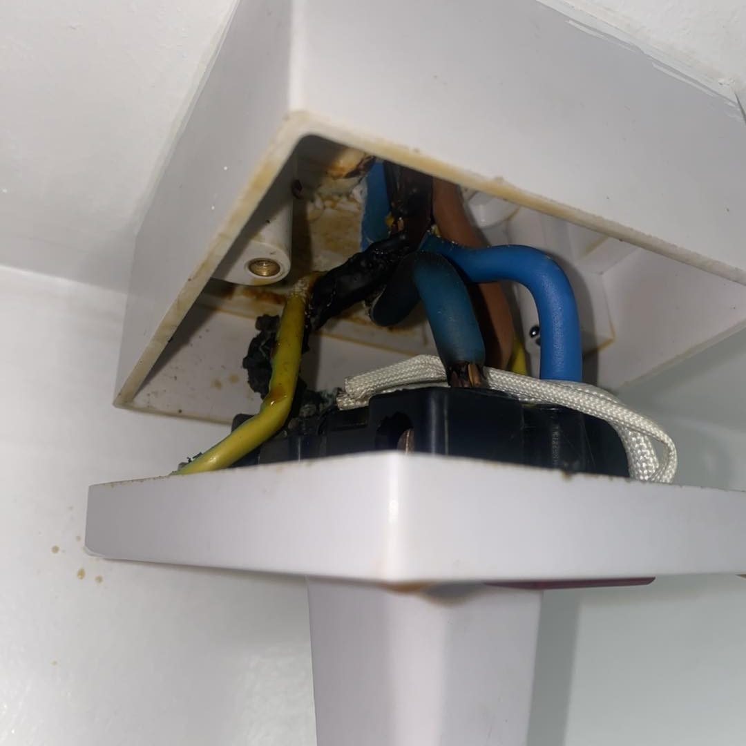 Wires in various colours connected to a white electrical junction box. burnt out